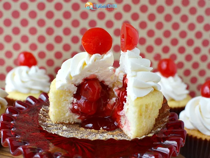 white cupcakes with cherries spilling out onto the plate