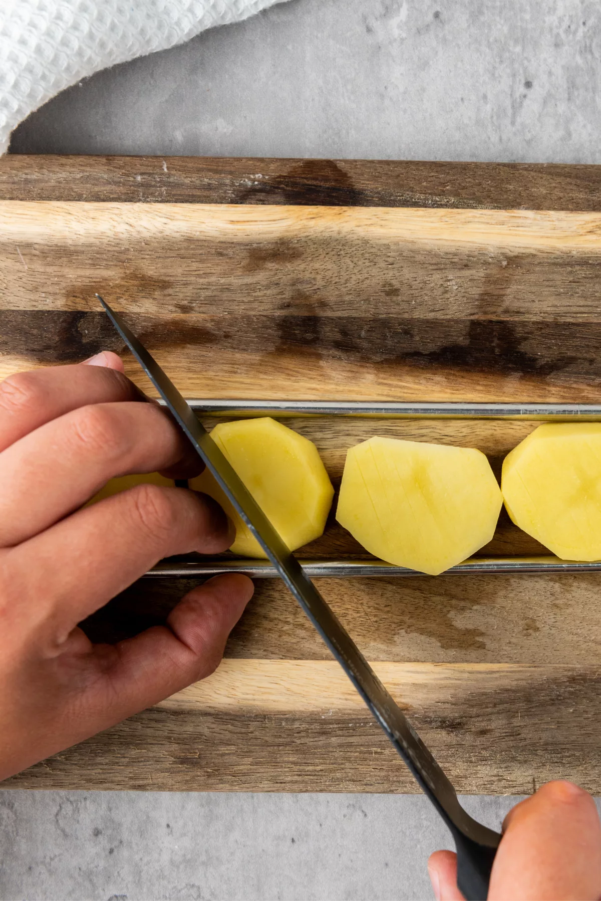 potato being cut on a cutting board