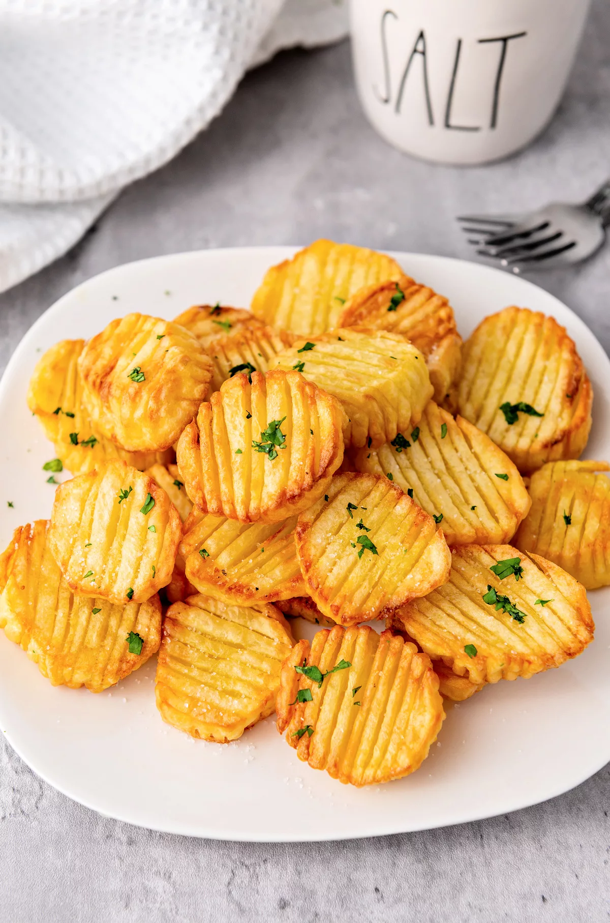 accordion potatoes on a plate topped with parsley