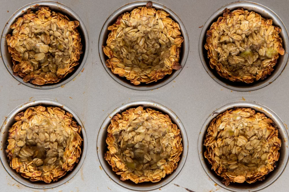cooked granola cups in a muffin tin