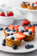 Granola Cups filled with yogurt and fresh berries on a white plate
