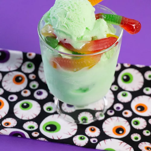 green sorbet with gummy worms in a dessert dish