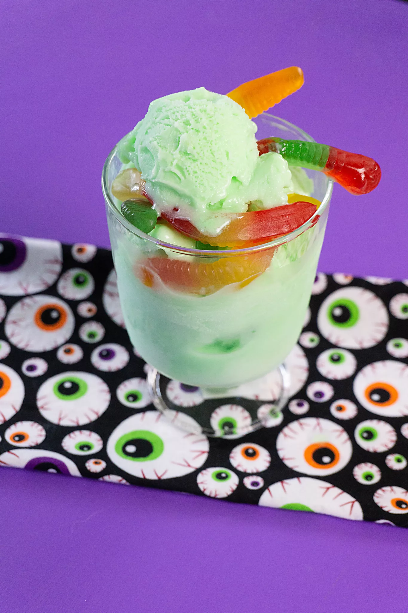 green sorbet with gummy worms in a dessert dish