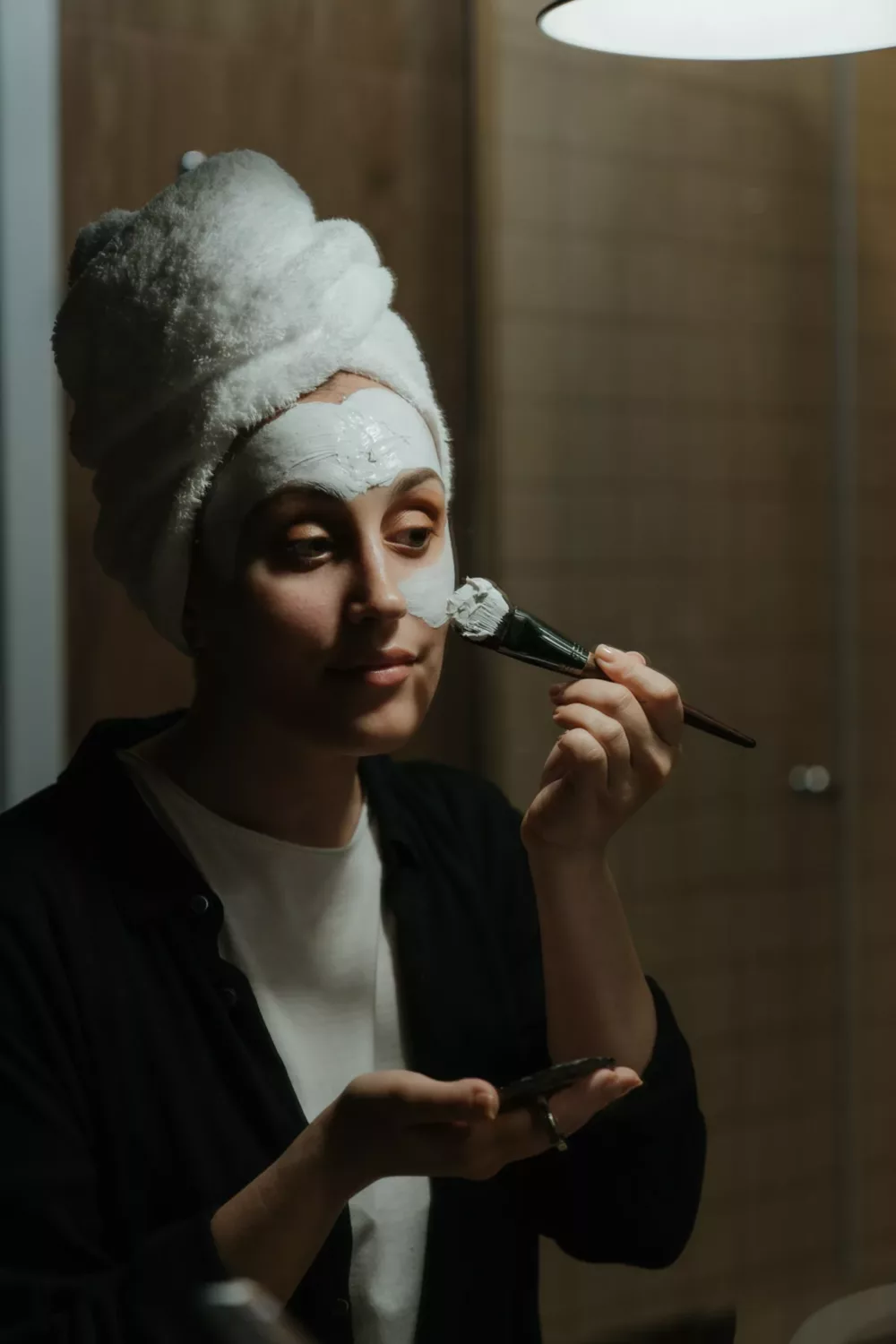 using a brush to apply exfoliant to the face