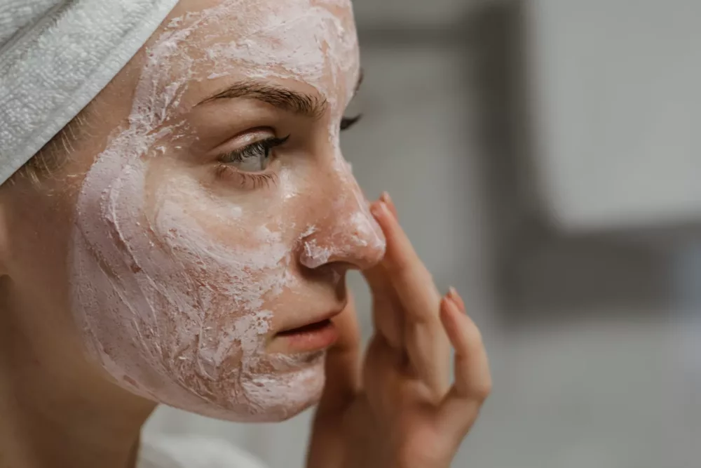 person putting on facial cream