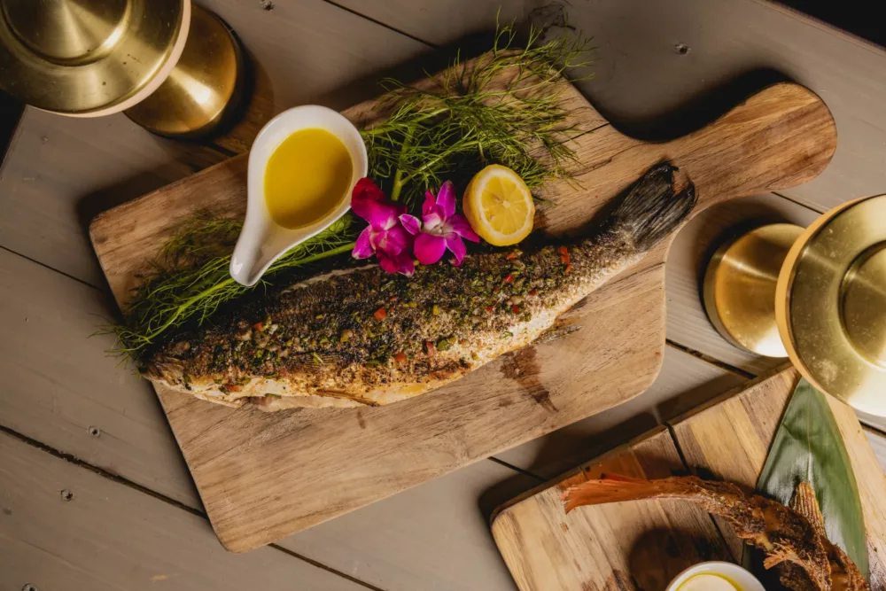 whole fish on a wooden plank at Maü Miami  for Miami Spice 2023