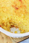 Paula Deen Corn Casserole in a casserole dish and topped with melty cheese