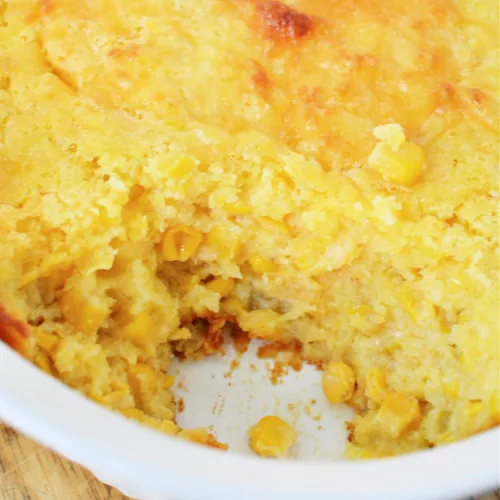 Paula Deen Corn Casserole in a casserole dish and topped with melty cheese