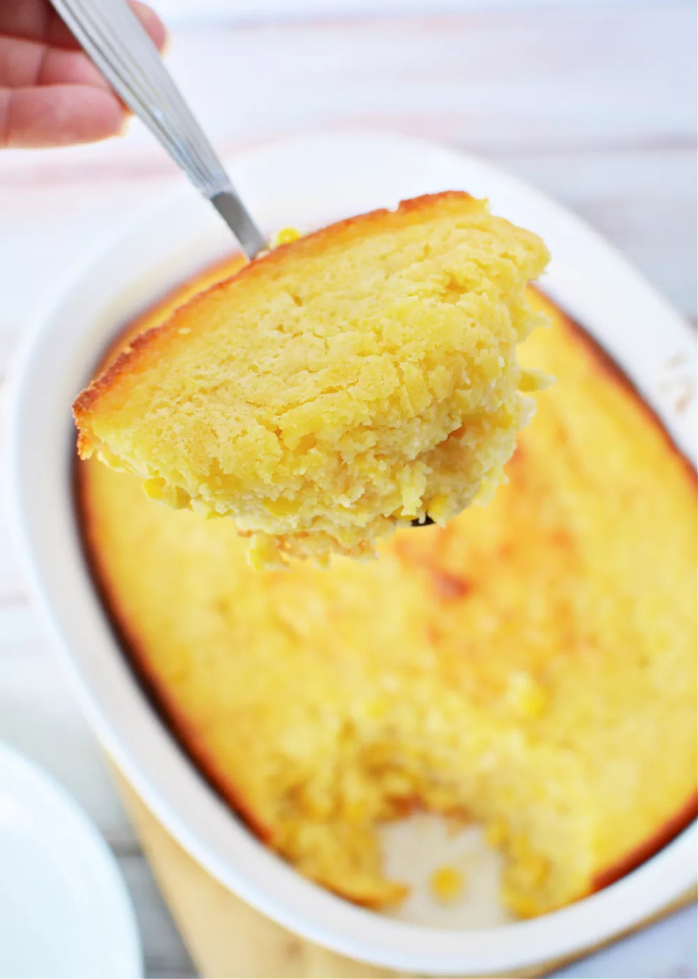 Corn Casserole in a casserole dish and topped with melty cheese