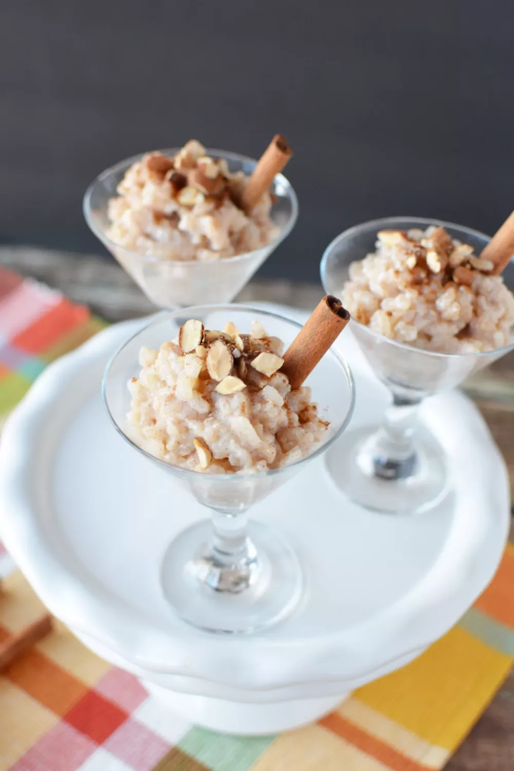 Overhead shot of almond milk rice pudding in dessert glasses garnished with cinnamon sticks