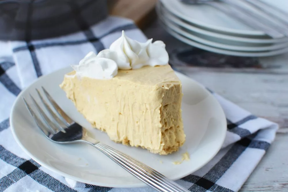 creamy light yellow pumpkin pie cake topped with whipped cream topping