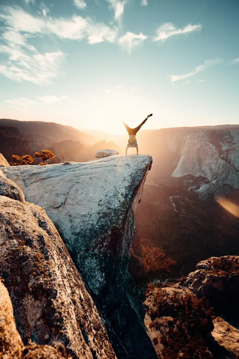 person doing a handstand on a cliff