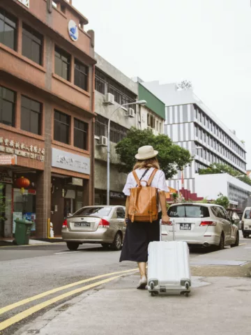 woman rolling a suitcase along a street