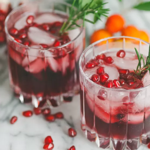 Pomegranate Wine in a glass with ice and seeds