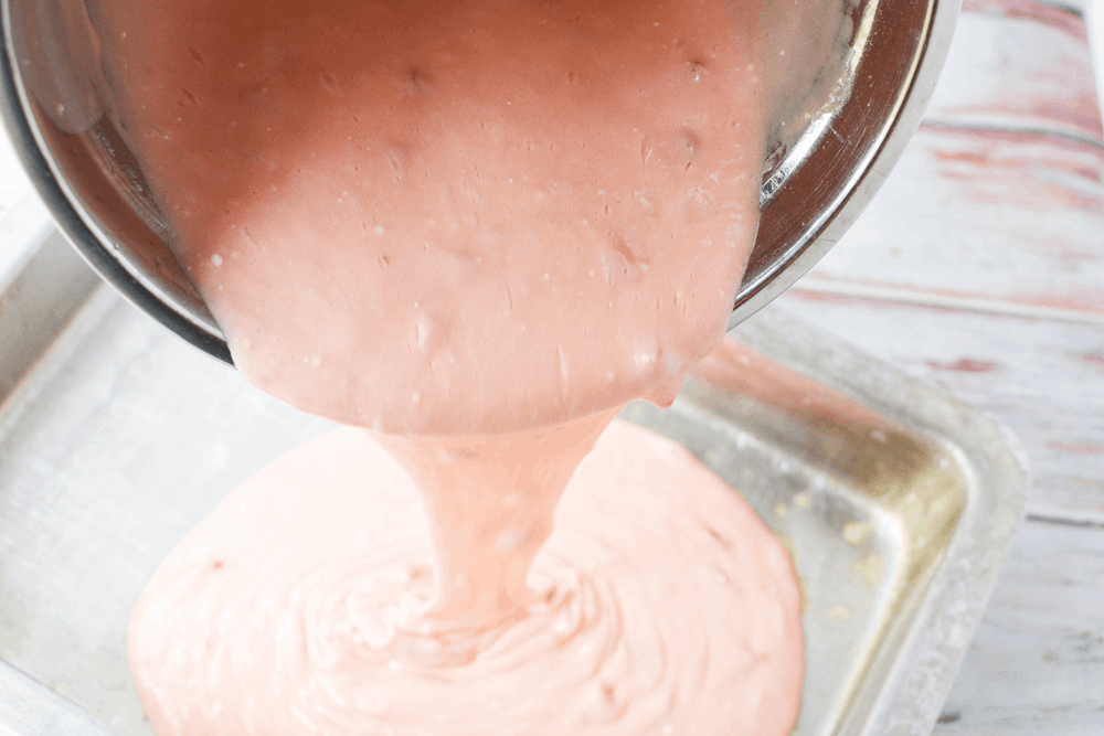 cake batter being poured into a baking pan
