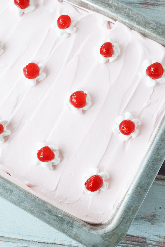 Overhead shot of frosted cherry chip cake in baking dish.
