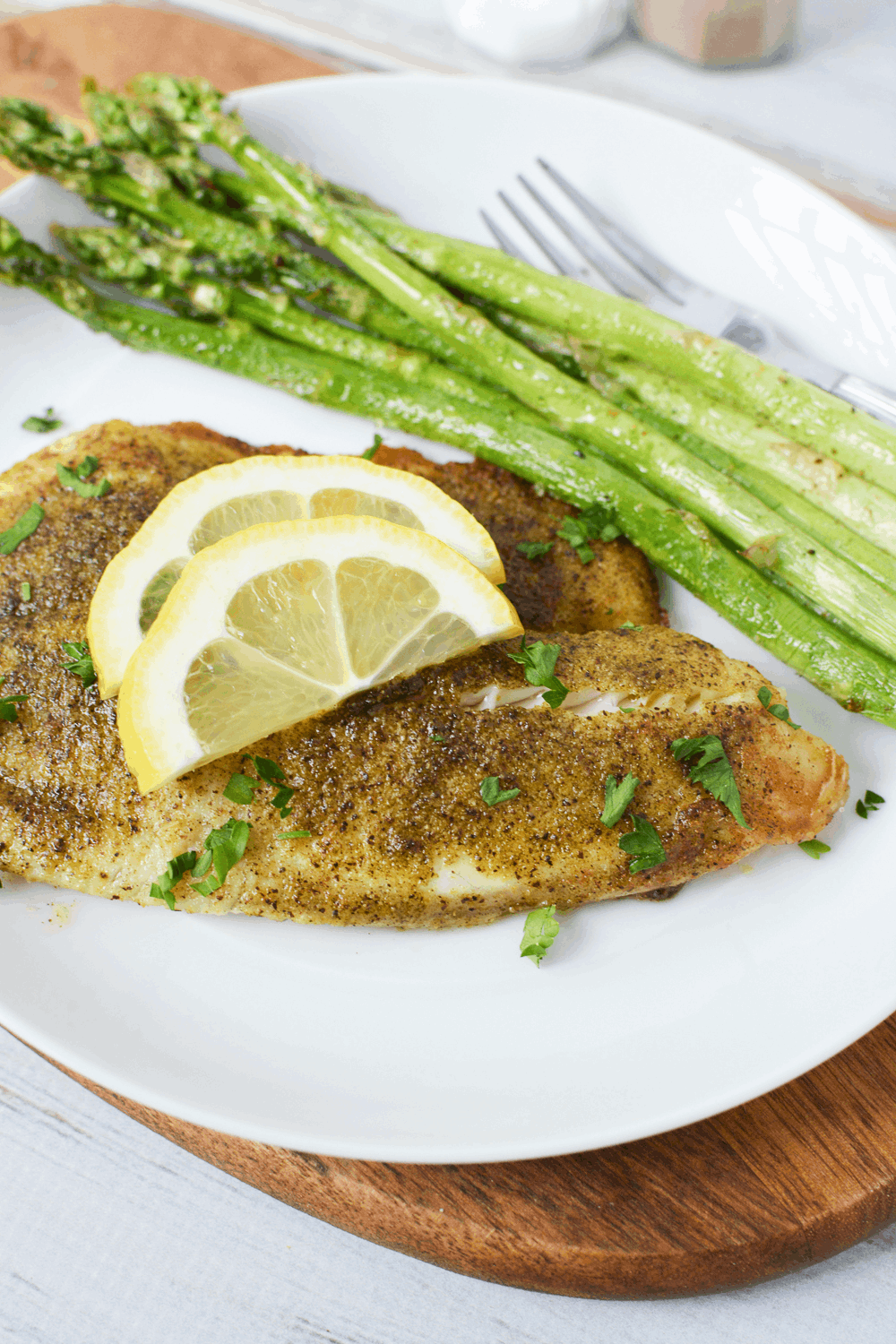 Closeup shot of air fryer frozen fish fillets with asparagus on plate