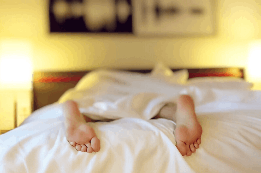 a pair of feet hanging over a bed