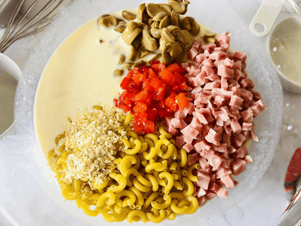Overhead shot of macaroni and ham casserole ingredients in mixing bowl. 