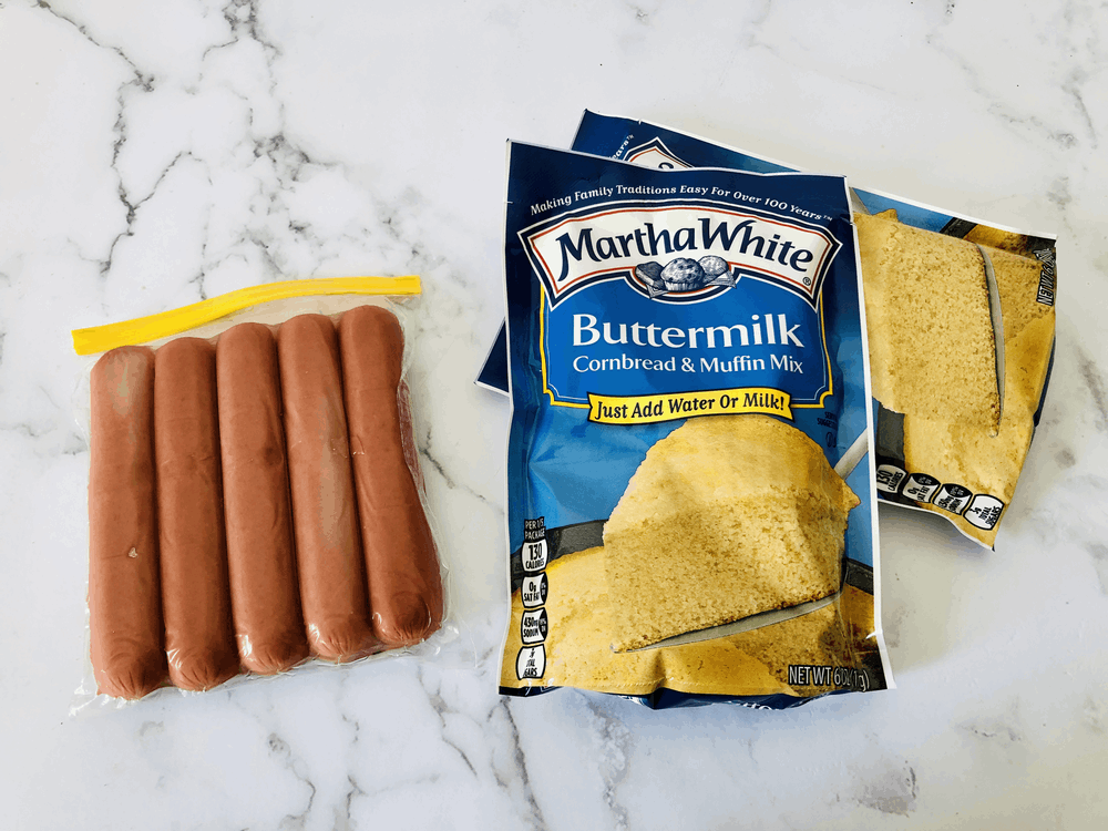 Package of hot dogs and two packages of cornbread mufin mix. 