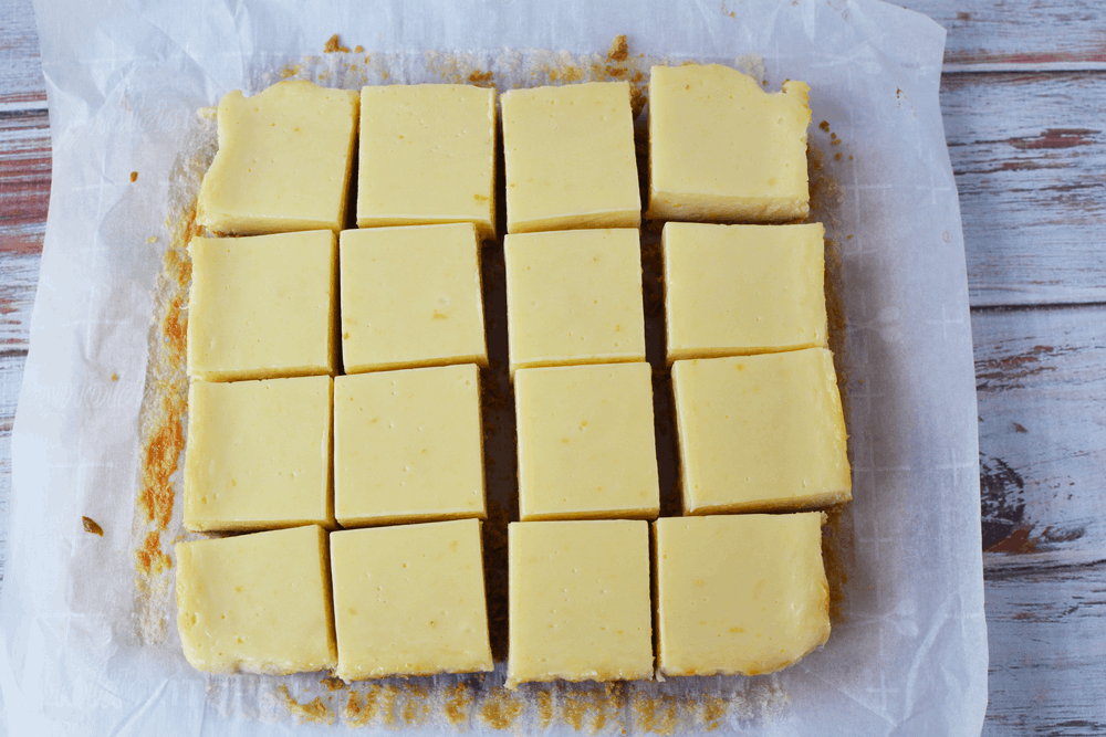 Overhead shot of lemon bars with graham cracker crust on parchment paper. 