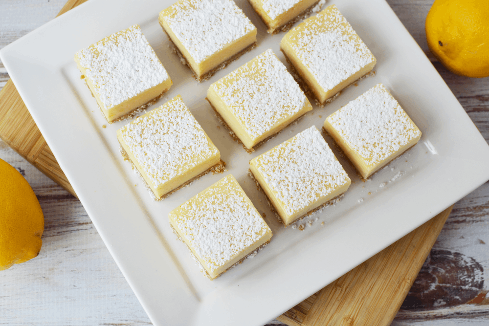 Lemon Bars with Graham Cracker Crust cut into squares on a platter