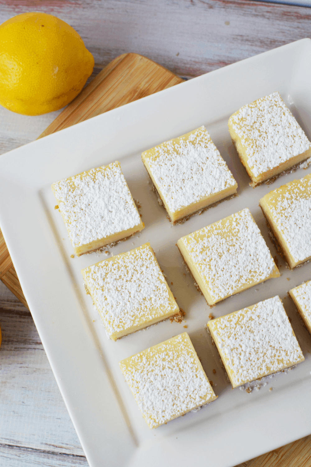 Lemon Bars with Graham Cracker Crust cut into squares on a platter