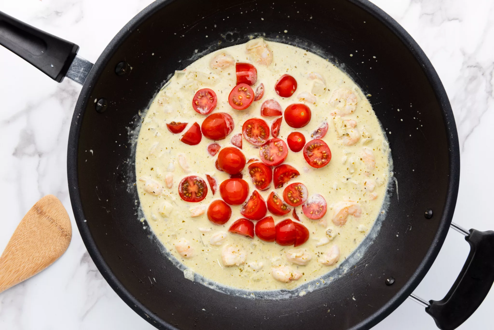 cherry tomatoes in a heavy cream sauce in a frying pan