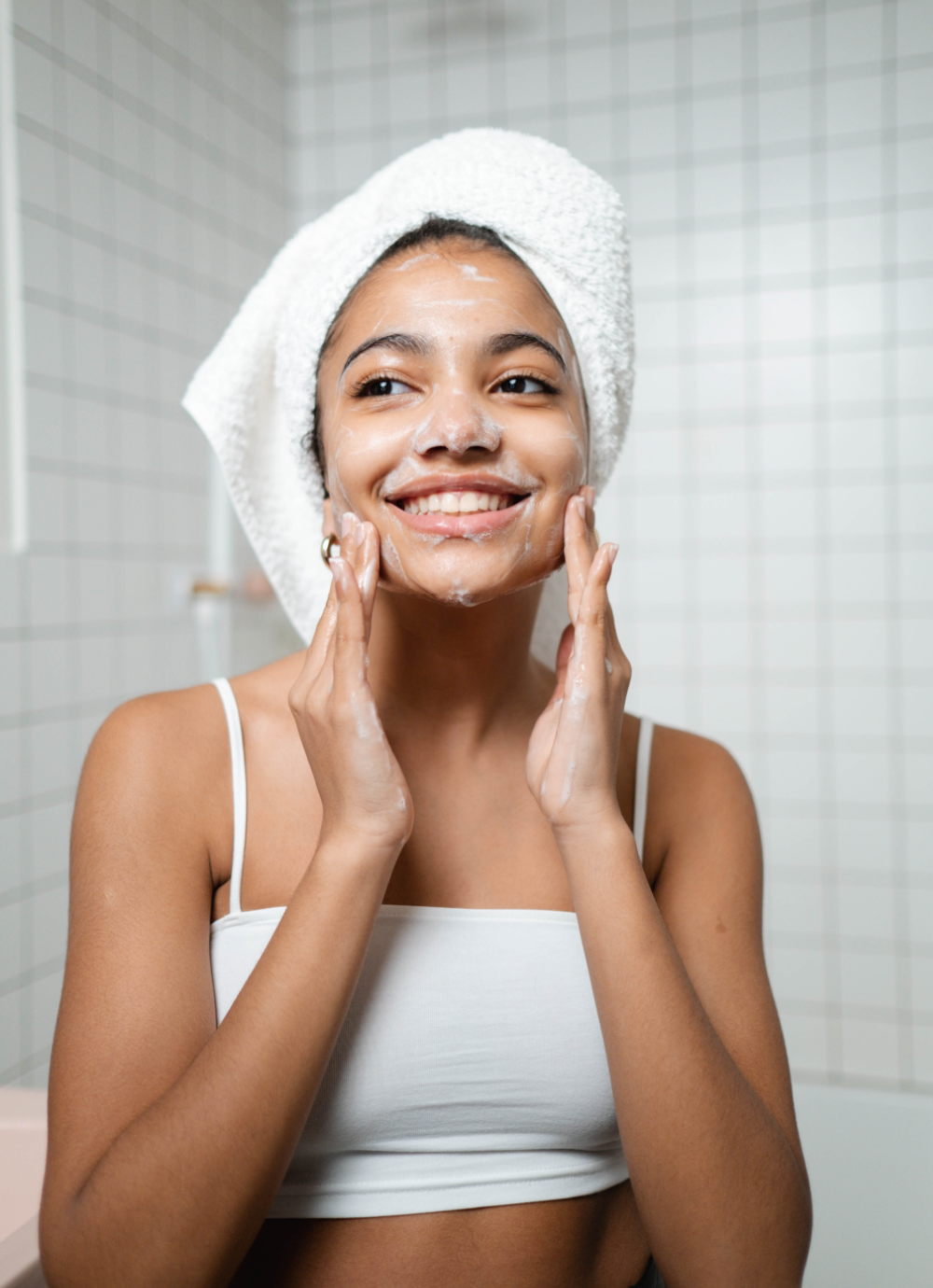 woman smiling while washing her face