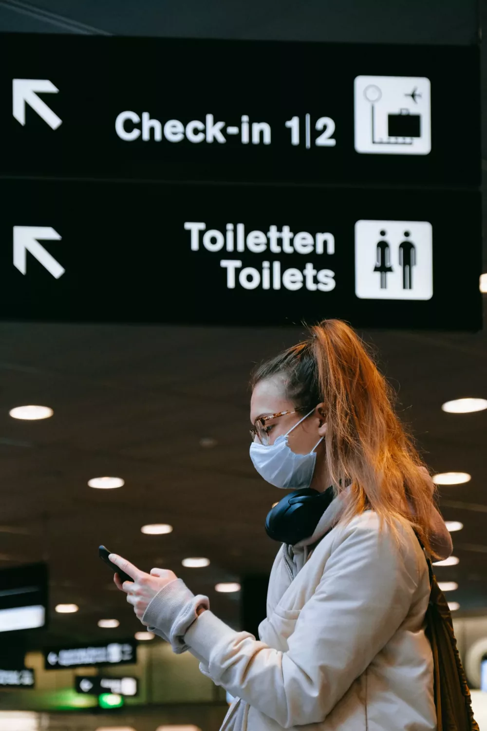 woman checking her phone in an airport