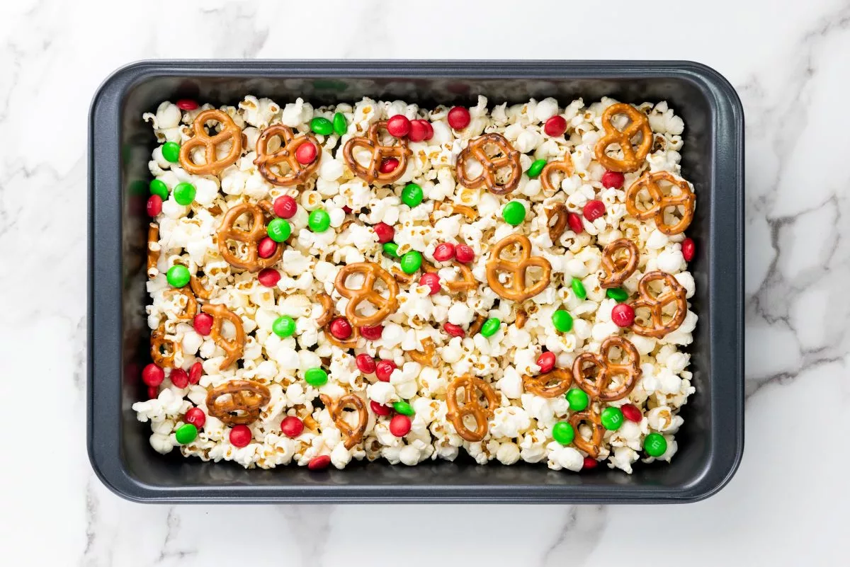 Overhead shot of popcorn, pretzels, and M&Ms in baking dish.