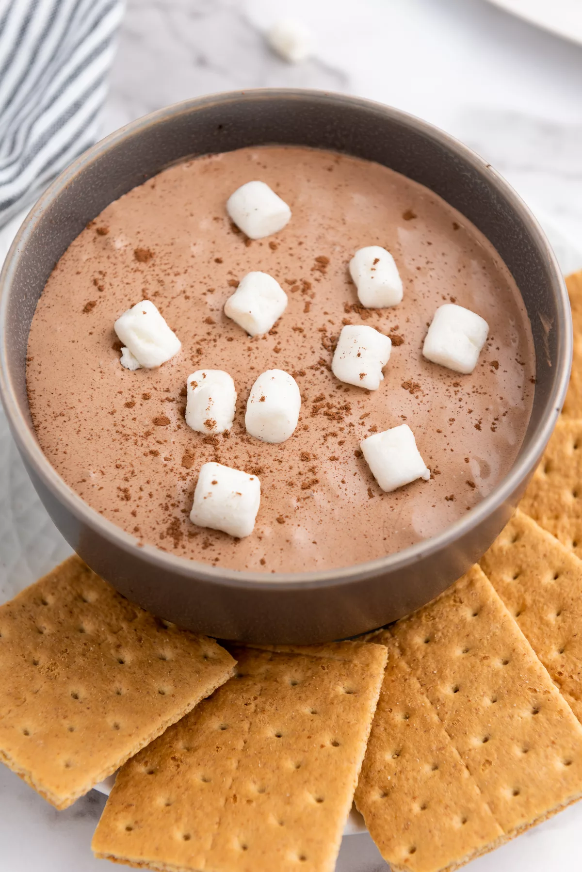 Hot Cocoa Dip in a bowl with mini marshmallows and graham crackers