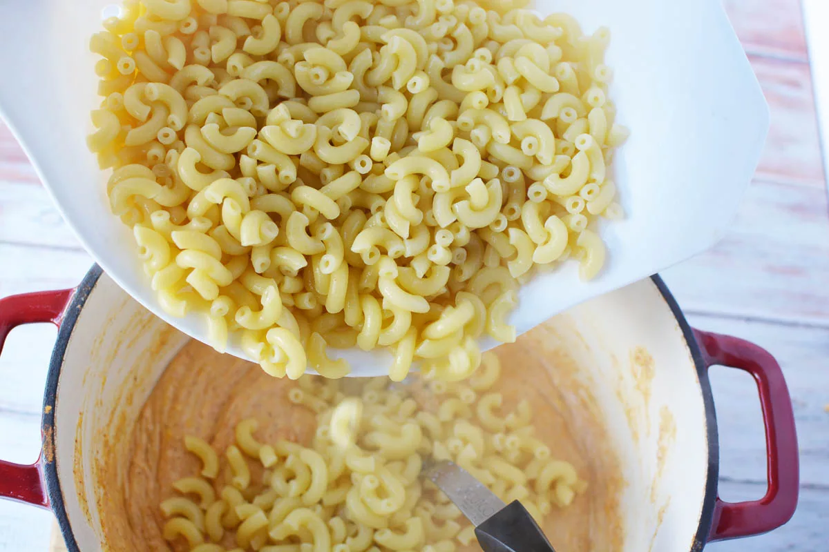 Adding cooked elbow macaroni noodles to the roux 