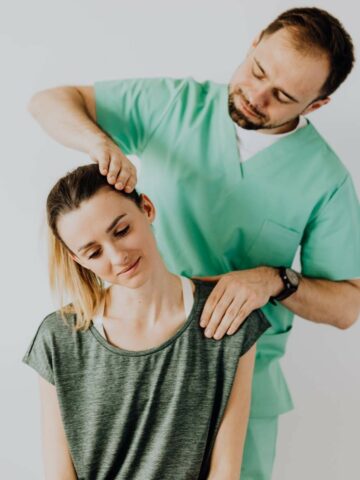 doctor treating a woman with a neck injury