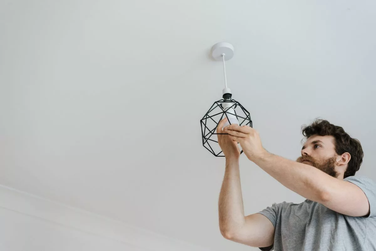person changing a light fixture