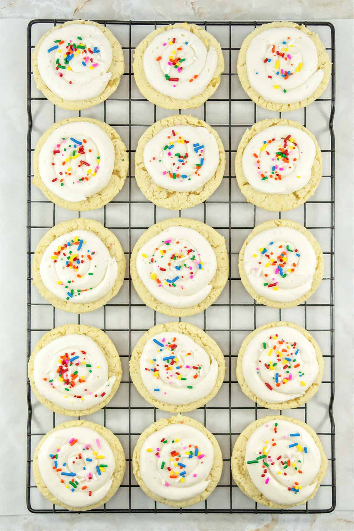frosted Sour Cream Cookies on a wire cooling rack