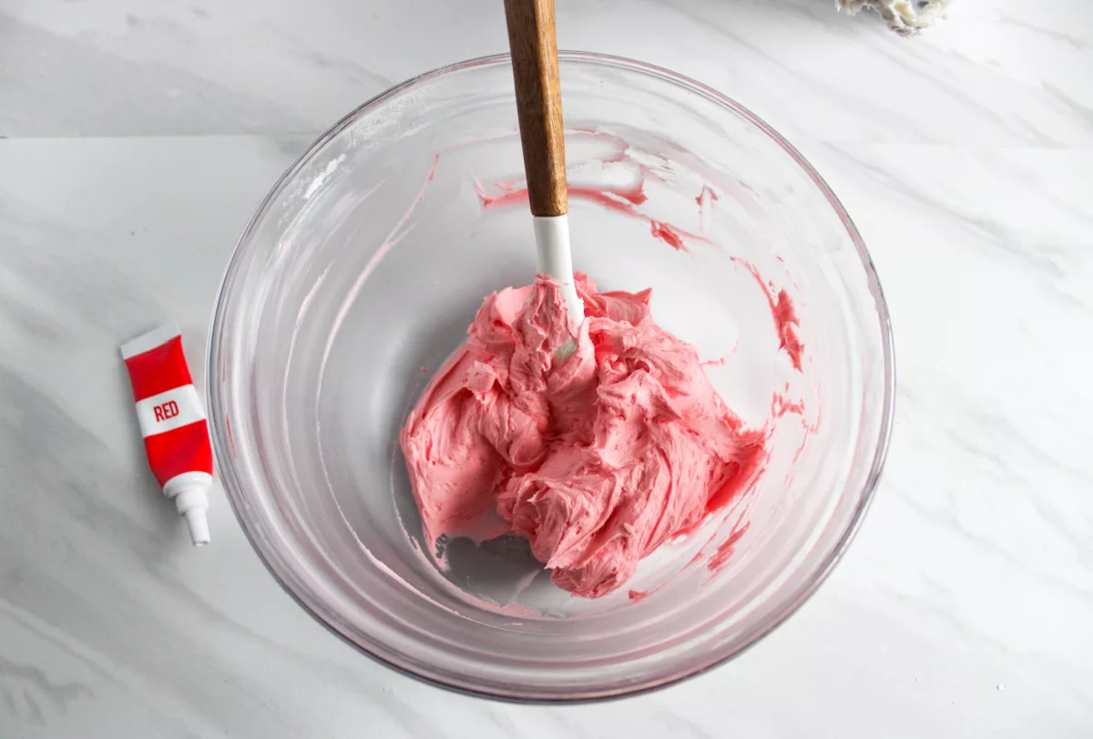 pink buttercream being mixed in a bowl