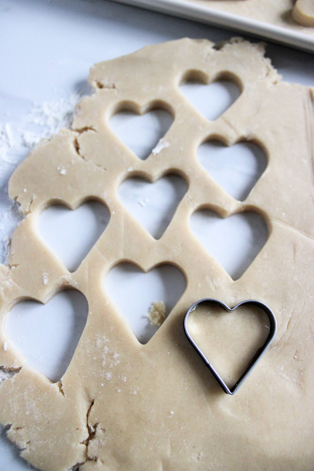 cookie dough being cut into hearts with a heart shaped cookie cutter