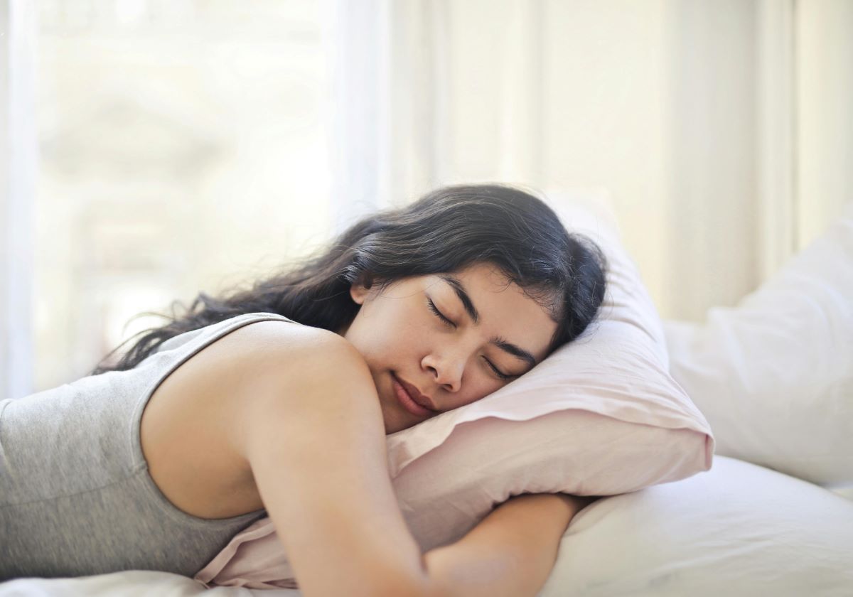 woman sleeping with a pillow in bed