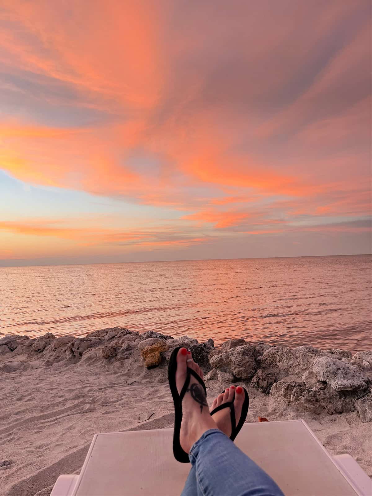 sandals on the beach at sunset