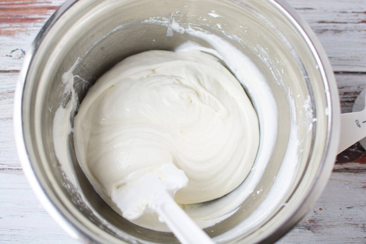 marshmallow fluff and cream cheese blended together in a mixing bowl