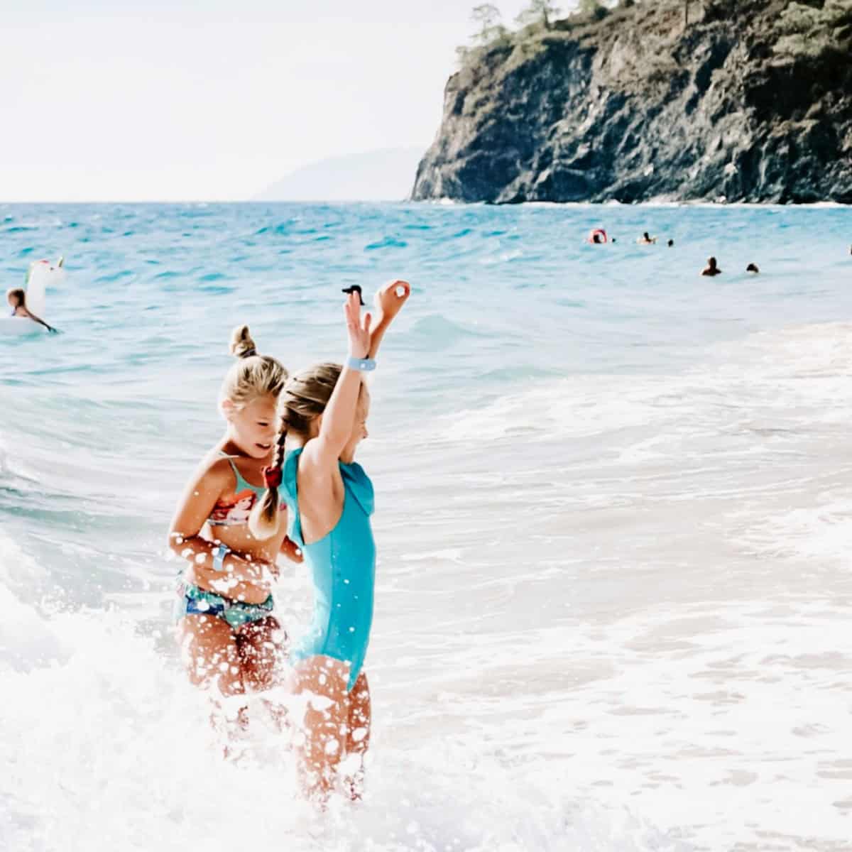 children playing in the waves at the beach