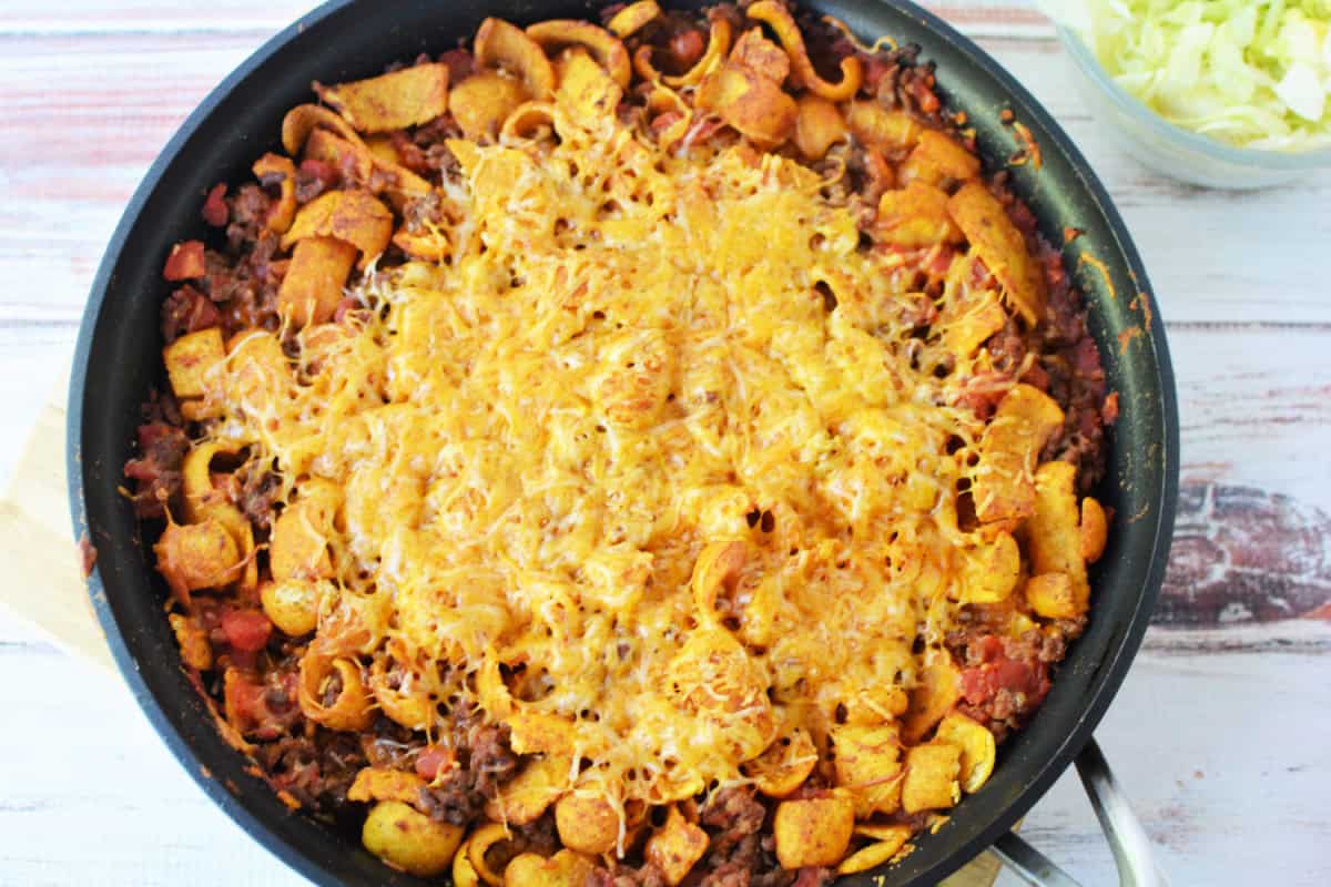 skillet filled with cooked casserole and melted cheese on top