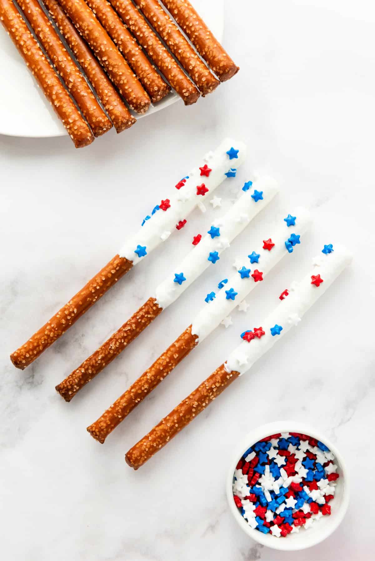 White Chocolate dipped pretzel rods with red white and blue star sprinkles