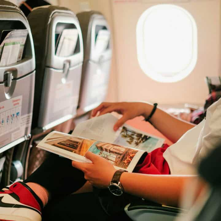 person reading a magazine on a flight