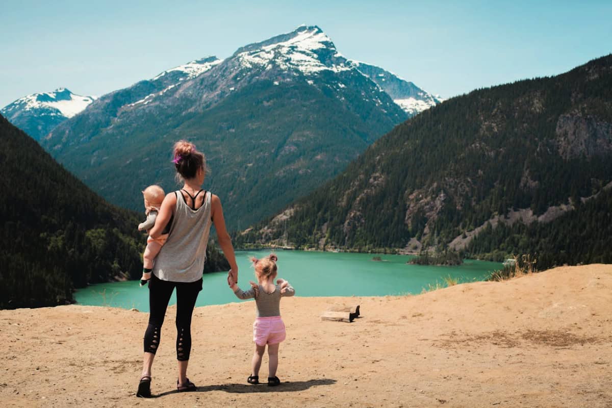 woman with two children at the lake in the mountains