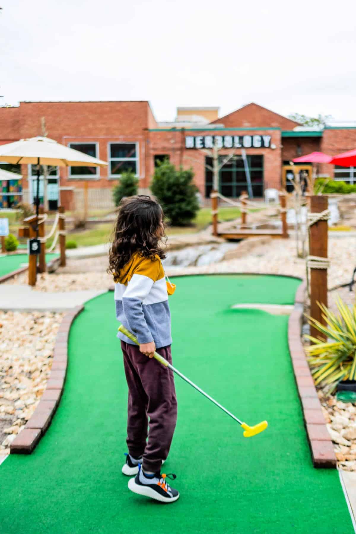 kid playing mini golf