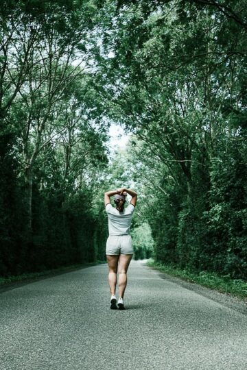 woman running down a wooded path