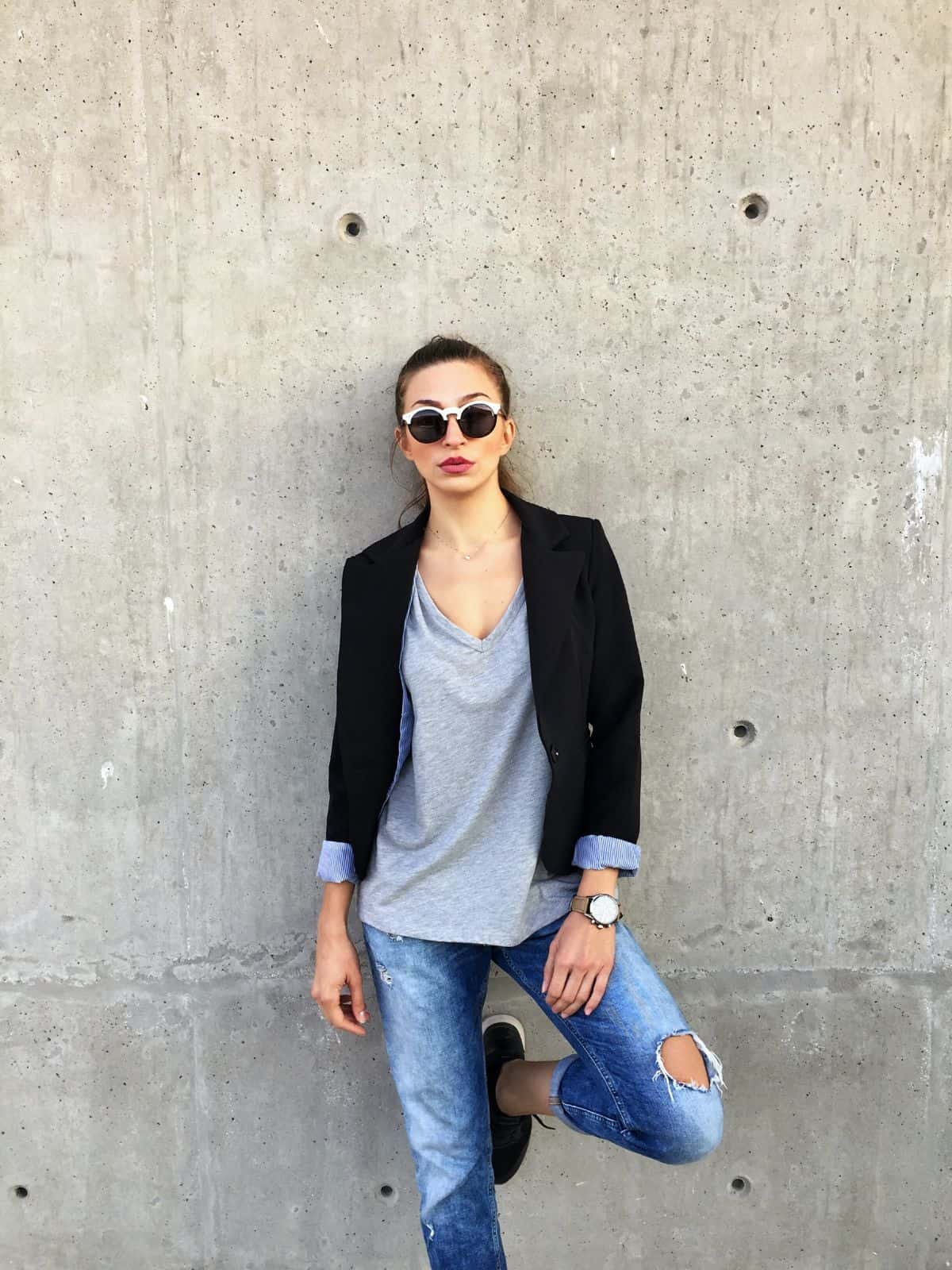 woman wearing streetwear in front of a gray wall