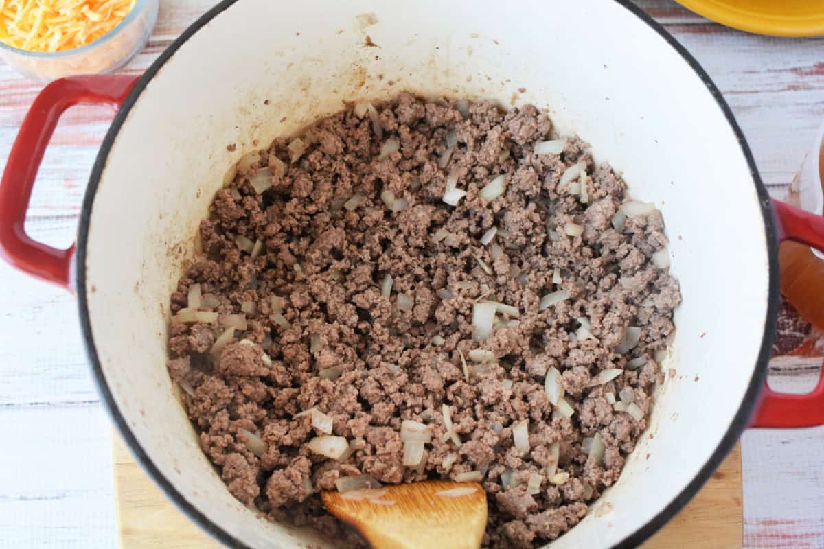 dutch oven filled with ground beef and diced onions